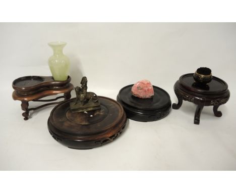 Group of four Chinese hardwood stands, small bronze figure, small green glass vase, cloisonne brush wipe and a pink stone spe