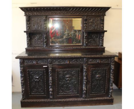 Victorian dark carved oak mirrored back sideboard, with centre bevelled mirror flanked by shells and all-over raised animal h