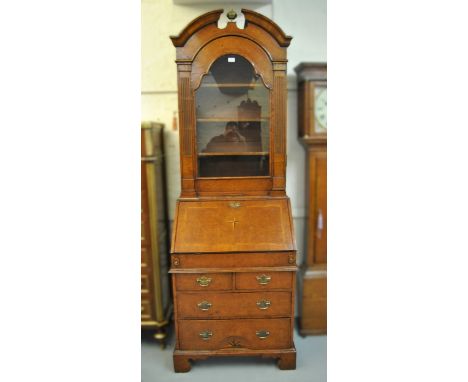 Walnut bureau bookcase in 18th Century style, the broken arch pediment top above an arched glazed door, the fall front with f