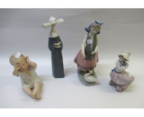 Two Lladro figures, a Nao figure and a bisque figure of a baby