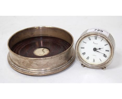 Circular London silver cased dressing table clock retailed by Asprey, together with a silver mounted wooden wine bottle coast