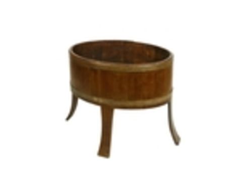 An oval brass bound Ash Planter, of coopered construction, on four bentwood splayed legs, 61cms x 74cms (24'' x 29''). (1)