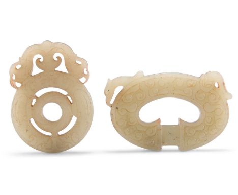 TWO JADE PLAQUES A PIERCED CIRCULAR JADE PLAQUE, surmounted by dragons, 4.7cm by 3.5cm; and A PIERCED PLAQUE, carved with clo