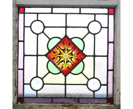 A LEADED STAINED GLASS WINDOW A LEADED STAINED GLASS WINDOW, a central red and yellow foliate pane surrounded by yellow glass