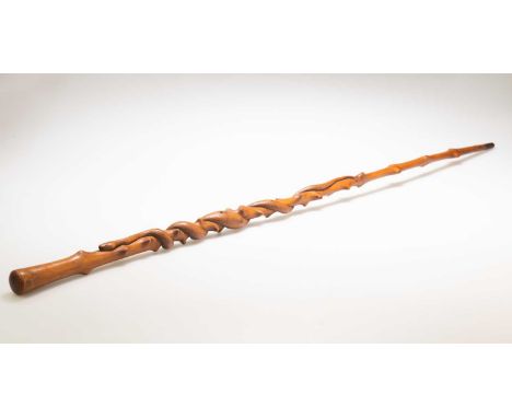 A 19TH CENTURY CARVED WALKING STICK A 19TH CENTURY CARVED WALKING STICK, probably beech, carved depicting a snake coiled arou