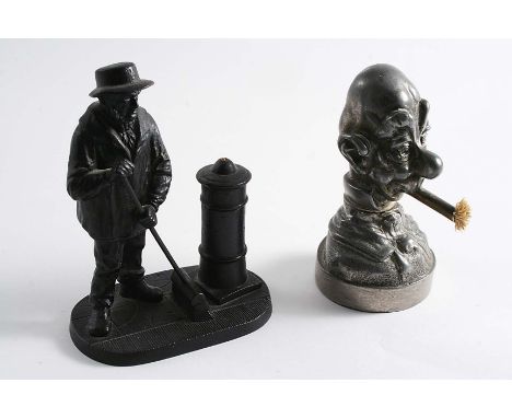 A LATE VICTORIAN PEWTER TABLE LIGHTER / VESTA STRIKER in the form of the bust of "Ali Sloper", with Registered design no. "20