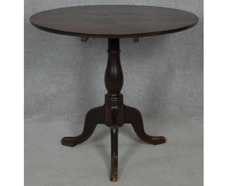 A Georgian oak tilt top occasional table on baluster turned pedestal and tripod cabriole supports. H.75 D.82.5cm 
