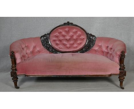 A Victorian carved walnut framed sofa in deep buttoned velour upholstery on fluted tapering supports. H.92 W.175 D.75cm 