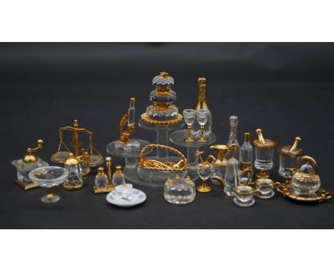 A collection of twenty three Swaovski crystal memories with gilt metal detailing and display stand. Including revolving three