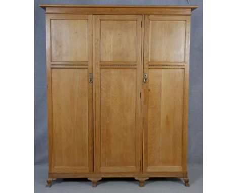 A C.1900 light oak fitted wardrobe with hanging section and fitted with linen slides and drawers on squat cabriole supports. 