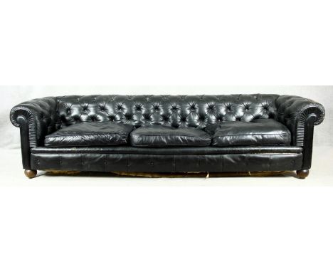A three seater Chesterfield sofa in deep buttoned leather upholstery on bun feet. H.70 W.275 D.90cm 