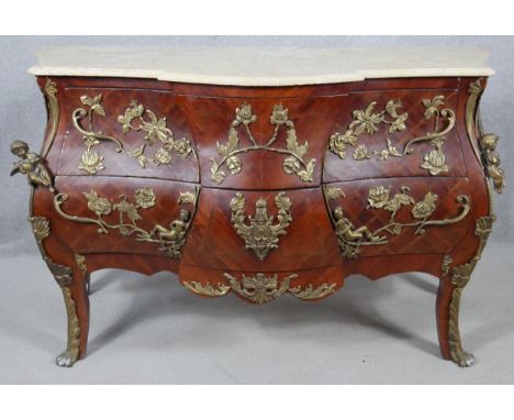 A 19th century French style kingwood bombe commode with shaped marble top and all over scrolling foliate and cherub ormolu mo