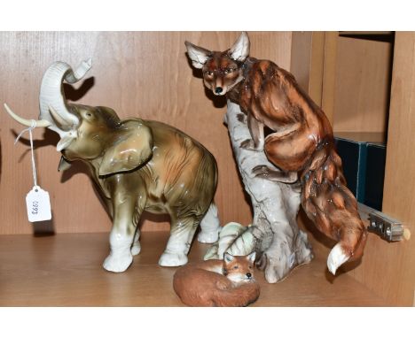 A ROYAL DUX ELEPHANT AND TWO FOX FIGURINES, comprising a 20th Century Royal Dux pottery figure of an elephant, trunk raised, 