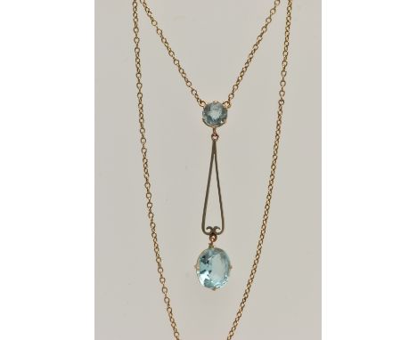 AN EARLY 20TH CENTURY YELLOW METAL PENDANT NECKLACE, the drop pendant set with a pale blue oval cut paste, from an openwork s