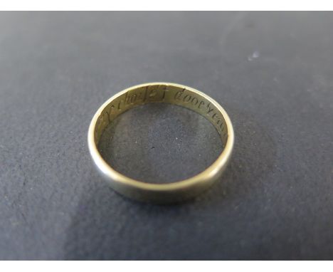A gold band ring believed to be above 18ct with inscription - ring size R/S - Weight approx. 3.8gms 