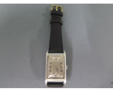A Cyma steel cased gents wristwatch, rectangular silvered dial with Arabic numerals, subsidiary seconds at 6 o'clock on leath