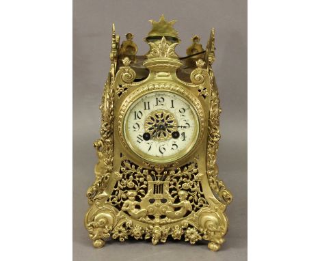AN ORNATE FRENCH GILT METAL BRACKET CLOCK of spreading square section form, cast and pierced throughout with scrolling foliag