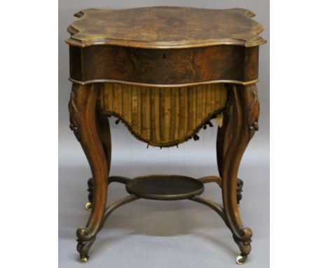 A VICTORIAN WALNUT WORK TABLE of serpentine rectangular form having a hinged quarter veneered top, sectioned and material lin