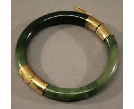A 19TH CENTURY CHINESE GOLD MOUNTED SPINACH JADE BRACELET of circular form. 8cm(d) CONDITION: Good