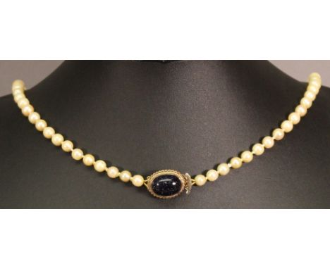 A PEARL NECKLACE, the string of pearls with 9ct gold clasp inset with oval glitter stone cabochon. 52cm(L)  CONDITION: Genera