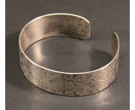 A MODERN SCOTTISH SILVER BANGLE of open form moulded with Celtic designs, marks for Edinburgh 1986, maker ACC. 6cm, 33grams  