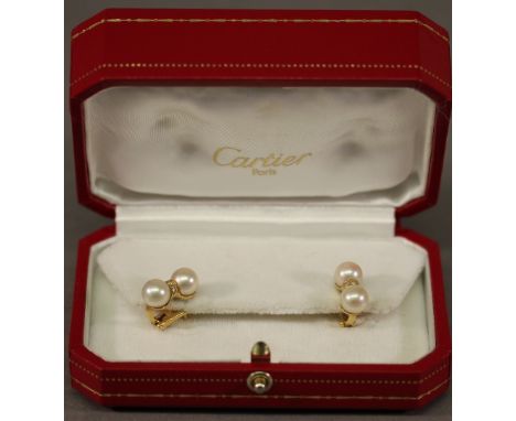 A PAIR 18CT GOLD AND PEARL CARTIER EARRINGS comprising two pearls separated by a diamond chip-set band, hinged clasp, marked 