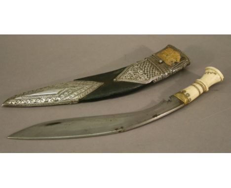 A BONE-HANDLED NEPALESE KUKRI, the bone handle signed, the leather scabbard with embossed white metal mounts and gilt leaf de
