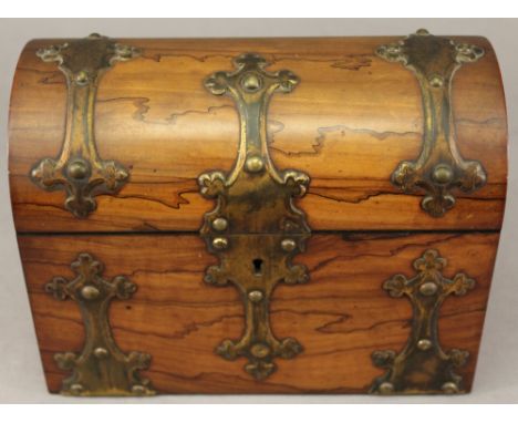 A LATE 19TH CENTURY WALNUT TEA CADDY of domed rectangular form with applied gilt metal mounts, the interior with two domed co