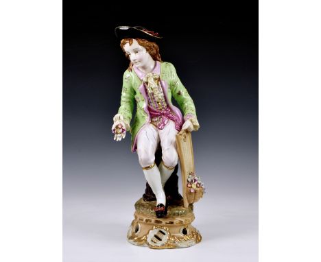 An oversized Meissen porcelain style Dandy figurine, the Dandy sitting apon a tree trunk, wearing flat cap,18th century three