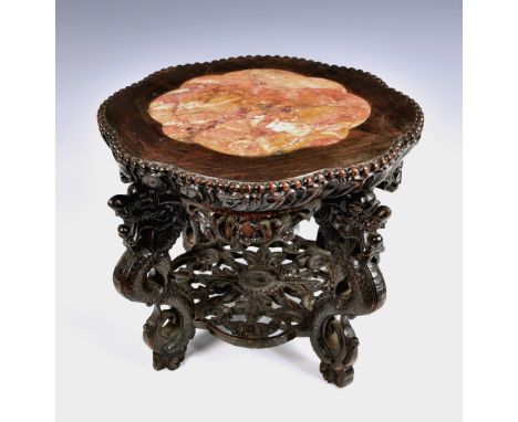 A Chinese carved hardwood jardinière stand, probably 19th century, the stand inset with shaped rouge marble top, foliate carv