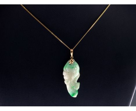 A 14ct gold and carved jade carp pendant, 4.1cm. long, with 9ct gold trace-link chain, approx. 42cm. long.. 