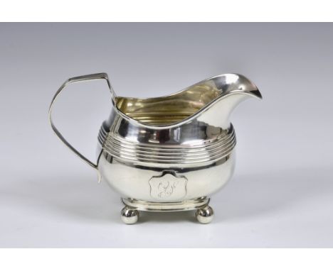 A George IV silver cream jug, James Wintle, London, 1820, of bellied rectangular form, having reeded decoration and applied s