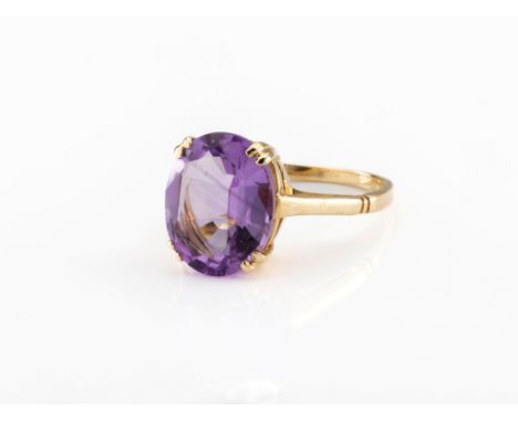 A 9ct gold and amethyst ring, set with an oval-cut amethyst, ring size M.. 