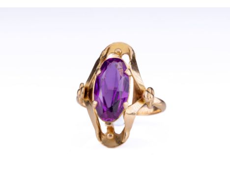 A 14ct rose gold and amethyst dress ring, the oval cut amethyst held in a 4 pronged setting on an elaborate, Art Nouveau styl