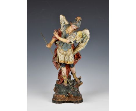 A 19th century painted and gilded terracotta figure of St Michael the Archangel slaying the Dragon, the polychrome painted fi