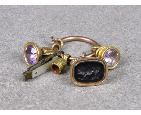 A base metal split ring with various 9ct and 15ct gold charms/fobs, to include two amethyst based fobs, one hardstone based f