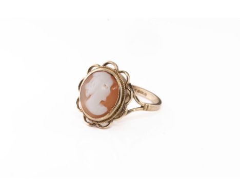 A 9ct gold and cameo ring, the shell cameo depicting a portrait of a lady, in an openwork scalloped setting over split should