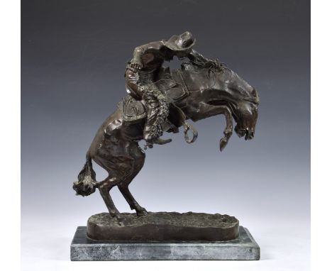 After Frederic Remington (American, 1861-1909), bronze "The Broncho Buster", modelled as a cowboy on rearing horse, dark brow