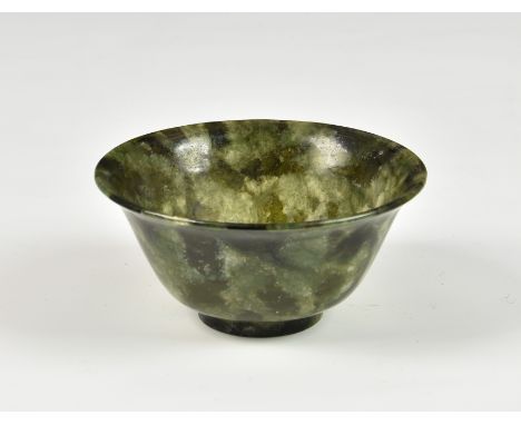 A Chinese carved spinach jade bowl, 20th century, with deep rounded sides rising to a flaring rim from a short circular foot,