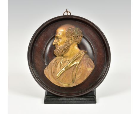 A gilt bronze relief profile portrait of a classical philosopher, on a turned mahogany plaque, overall 6in. (15.25cm.) diamet