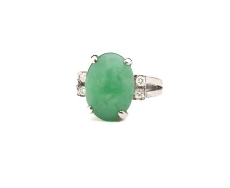 An 18ct white gold, jade and diamond dress ring, the oval, cabochon-cut jade held between pairs of brilliant cut diamonds on 