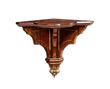 A fine 19th century rosewood and ormolu clock bracket, with break bowfront shelf on three panelled, shaped supports decorated