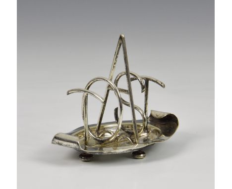A novelty Hukin &amp; Heath silver plate toast rack, the dividers spelling the word "TOAST", the dish of oval form with turne