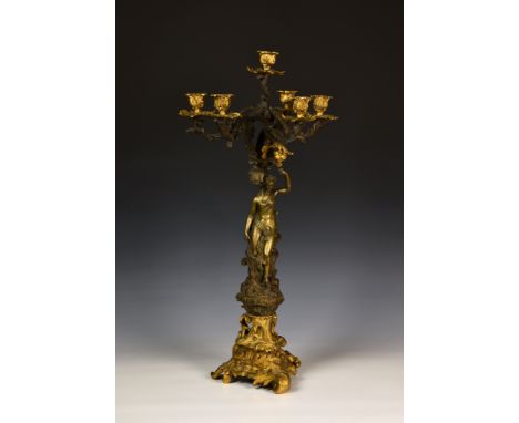 A French patinated and gilt bronze five branch candelabra, 19th century in the Louis XV style, the five, scrolled foliate arm