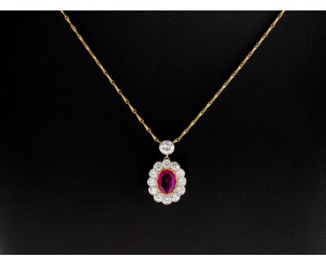An 18ct gold, ruby and diamond cluster pendant necklace, the oval-cut ruby within a surround of brilliant cut-diamonds, suspe