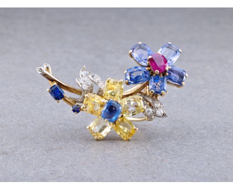 A sapphire, ruby and diamond floral spray brooch, by Cartier, one flower set with pale blue sapphires and a central ruby, the