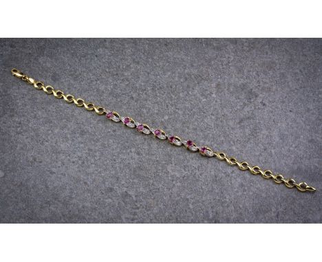An 18ct yellow gold, ruby and diamond bracelet, with seven pear cut rubies interspersed within seven pavé set diamond and yel