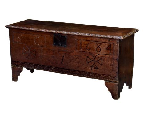 A 17th century and later oak six plank long coffer, the single plank top with later strap hinges and carved border, over a fr