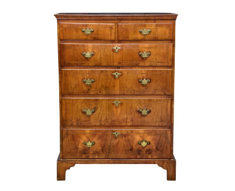 A George I and later six drawer tall walnut chest, the cross banded cavetto moulded top over two short and four long graduate