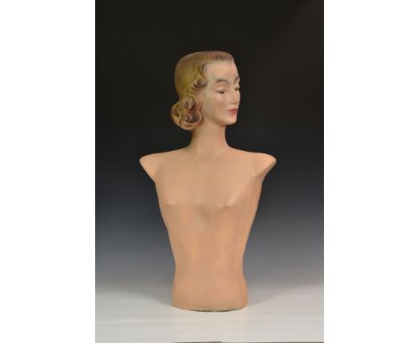 An Art Deco female plaster mannequin bust, having well detailed features with blue eyes and red lips, looking left, incised '